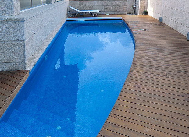 Piscina en Samil con escalera de obra corona de madera y cubierta de piscina